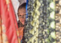 © Edo Potočnik - Zainteresirana prodajalka tekstila; na licih na kamnu strt puder za zaščito proti soncu, Bagan, Burma 2018